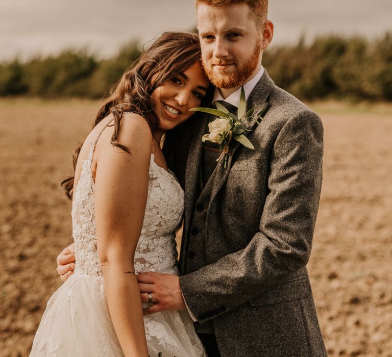 Bride and groom embracing on the field