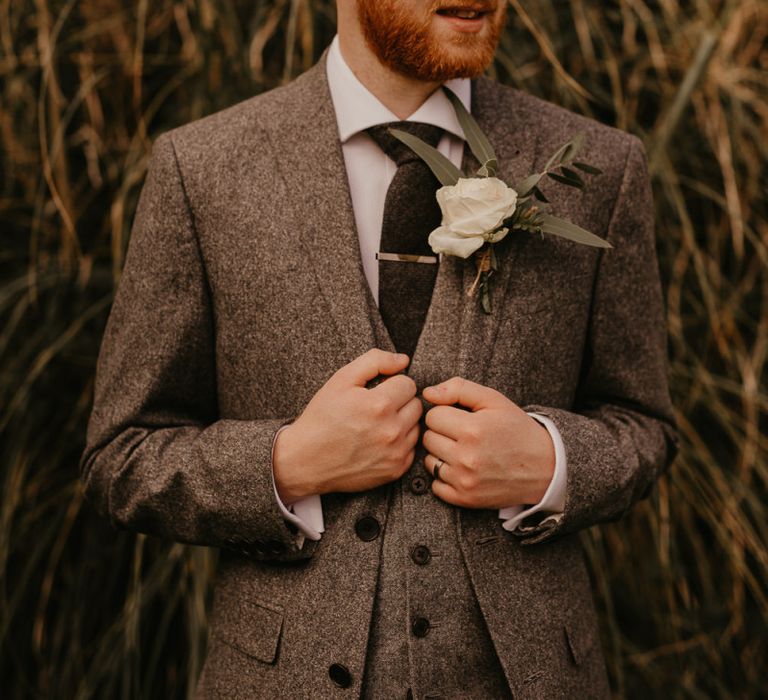 Groom in world suit for rustic wedding