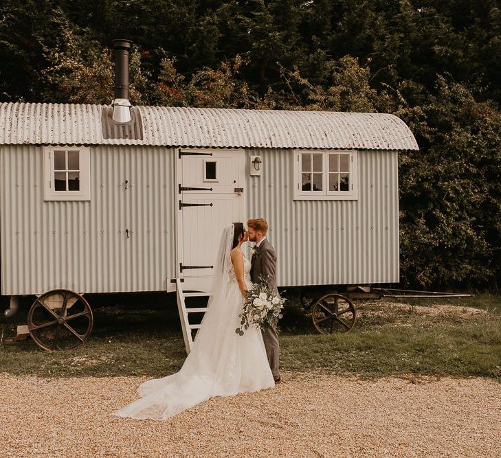 Bride and groom portrait in front of rural trailer