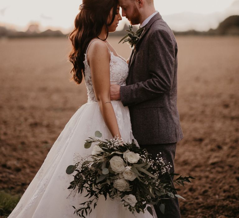 Bride and groom portrait in a field