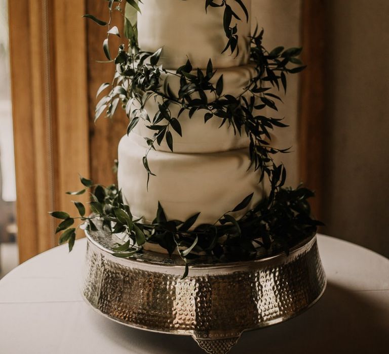 Homemade wedding cake covered in foliage