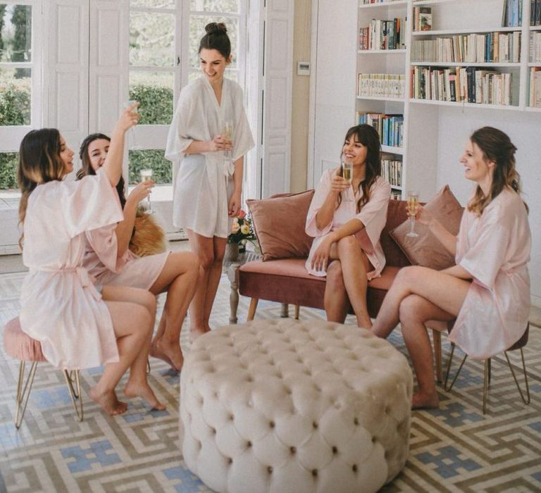 Bridal party drinking champagne in getting ready robes