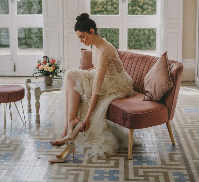 Bride in Lace Wedding Dress Putting on Bridal Shoes