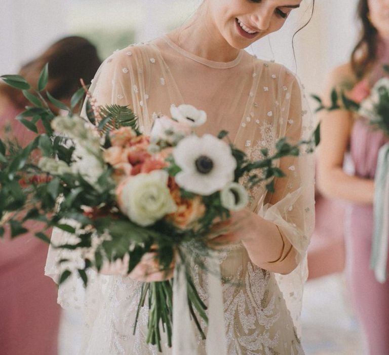 Bride with Messy Bun Looking at Her Wedding Bouquet