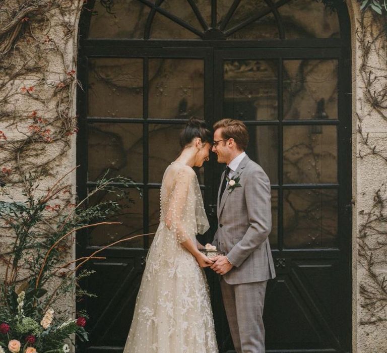 Bride and Groom Holding Hands in a Door way at Small Wedding