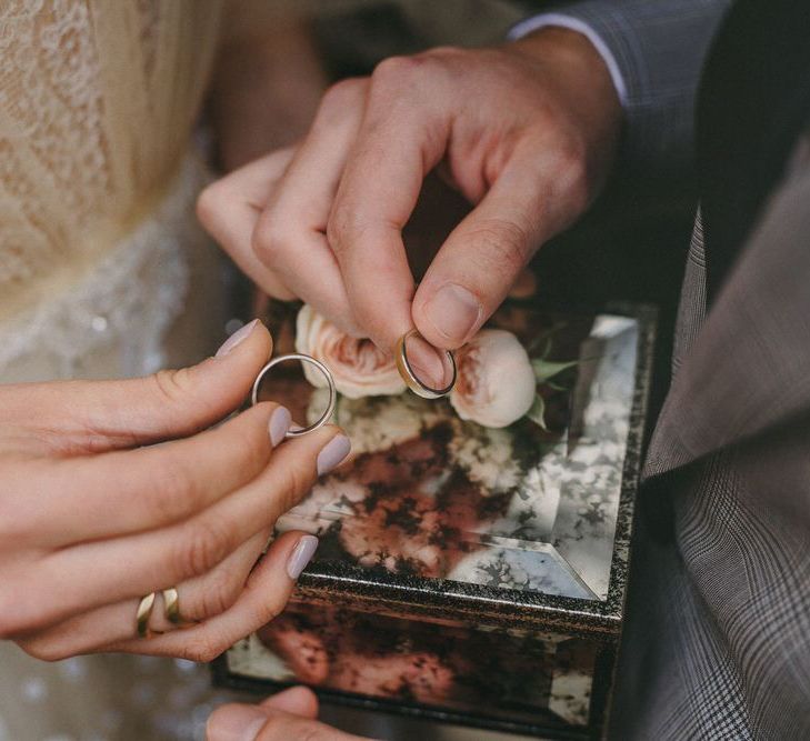 Wedding Rings in Glass Ring Box Filled with Flowers