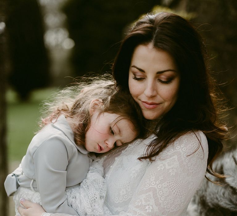 Bride in a Homemade Wedding Dress with Lace Bodice and Long Sleeves  Holding a Flower Girl