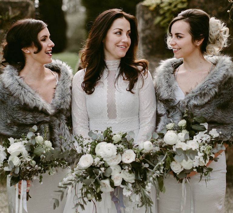 Bridal Party and Bridesmaids in Grey Satin Dresses with Fur Stoles and Bride in a Homemade Wedding Dress with Lace Bodice and Long Sleeves