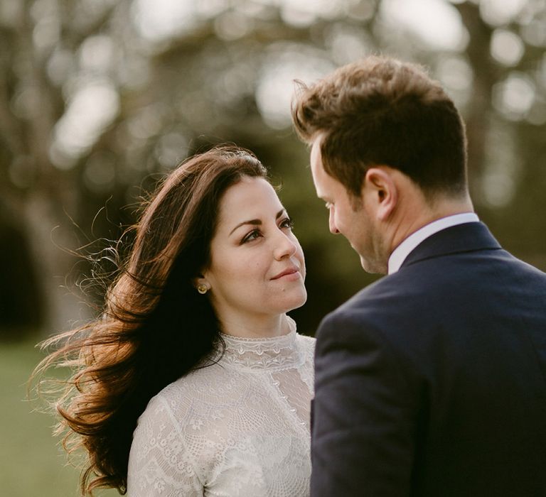 Bride in a Homemade Wedding Dress with Lace Bodice and High Neck, and Groom in Navy Suit