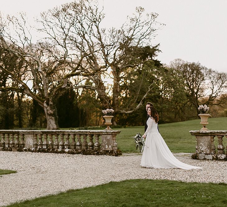 Bride in Homemade Wedding Dress with Lace Long Sleeves and High Neck and Groom in Navy Zara Suit