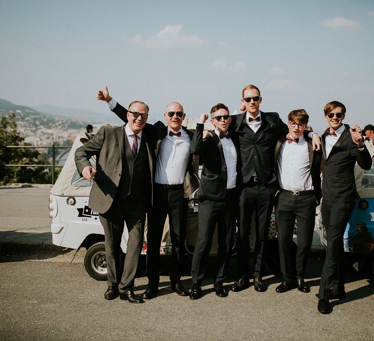 Groom in Black Three-Piece Suit from Hackett with Burgundy Bow Tie from Zara | Groomsmen in Black Tuxedo Suits from Moss Bros. with Burgundy Bow Ties from Zara | Tuk Tuk Wedding Transport | Budapest Wedding with Giant Bridal Bouquet, Tuk Tuks and Cadillac | Jágity Fanni Fotográfus