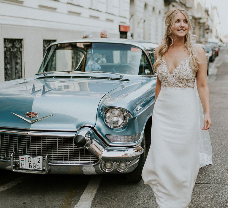 Vintage Blue Cadillac Wedding Car | Bride in Lila Gown by Alexandra Grecco with Fitted Silk Crepe Skirt and Sheer Italian Tulle Bodice Covered in Floral Lace Applique | Budapest Wedding with Giant Bridal Bouquet, Tuk Tuks and Cadillac | Jágity Fanni Fotográfus