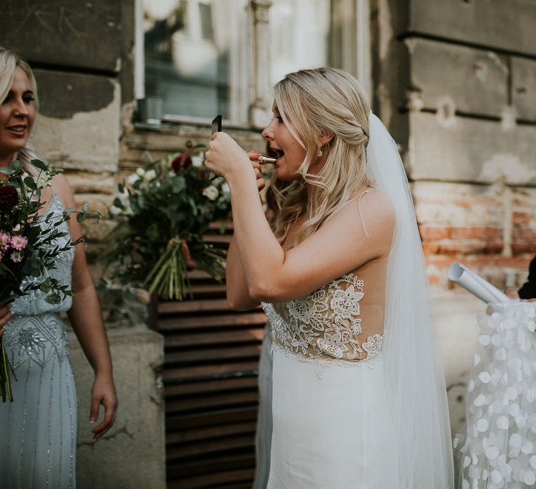 Bride in Lila Gown by Alexandra Grecco with Fitted Silk Crepe Skirt and Sheer Italian Tulle Bodice Covered in Floral Lace Applique | Theia Bridal Veil with Petal Detail | Oversized  Bouquet with Pink, Red and White Flowers and Foliage | Bridesmaid in Blue Drop Waist Dress with Spaghetti Straps and Beading | Budapest Wedding with Giant Bridal Bouquet, Tuk Tuks and Cadillac | Jágity Fanni Fotográfus