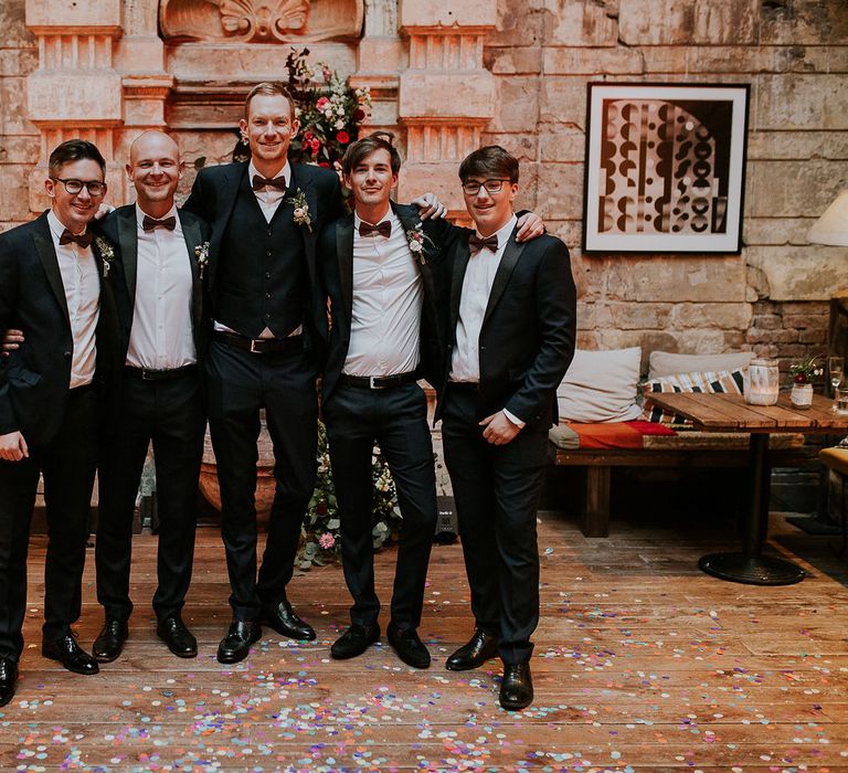 Groom in Black Three-Piece Suit from Hackett with Burgundy Bow Tie from Zara | Groomsmen in Black Tuxedo Suits from Moss Bros. with Burgundy Bow Ties from Zara | Budapest Wedding with Giant Bridal Bouquet, Tuk Tuks and Cadillac | Jágity Fanni Fotográfus