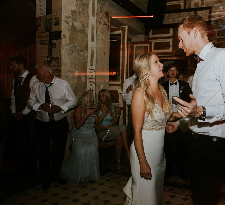 Bride in Lila Gown by Alexandra Grecco with Fitted Silk Crepe Skirt and Sheer Italian Tulle Bodice Covered in Floral Lace Applique | Groom in Black Three-Piece Suit from Hackett with Burgundy Bow Tie from Zara | First Dance at Brody Studios, Budapest, Hungary | Budapest Wedding with Giant Bridal Bouquet, Tuk Tuks and Cadillac | Jágity Fanni Fotográfus