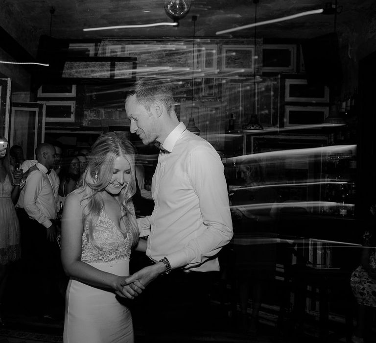 Bride in Lila Gown by Alexandra Grecco with Fitted Silk Crepe Skirt and Sheer Italian Tulle Bodice Covered in Floral Lace Applique | Groom in Black Three-Piece Suit from Hackett with Burgundy Bow Tie from Zara | First Dance at Brody Studios, Budapest, Hungary | Budapest Wedding with Giant Bridal Bouquet, Tuk Tuks and Cadillac | Jágity Fanni Fotográfus