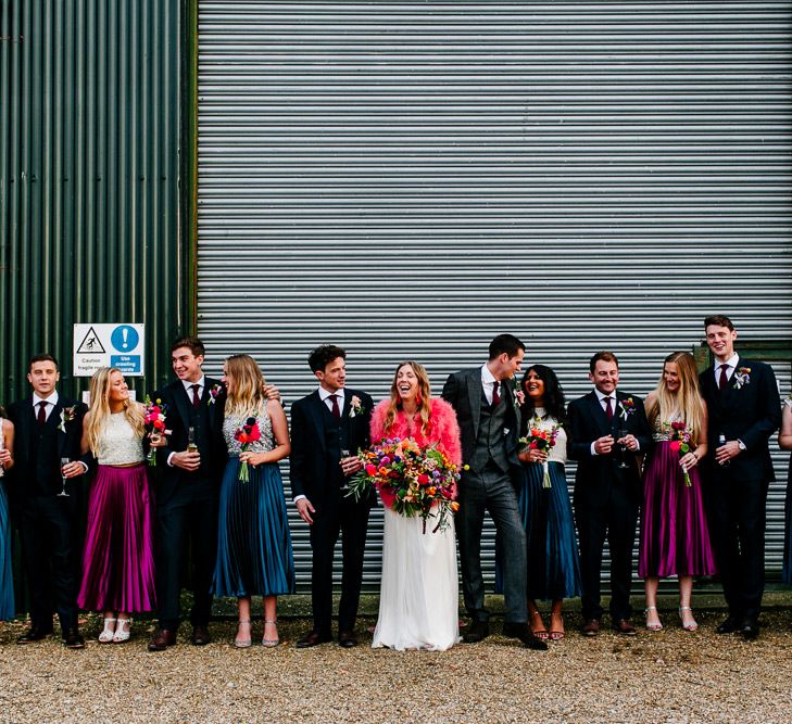 Wedding Party | Bride in Red &amp; White Joanne Fleming Design Wedding Dress | Pink Faux Fur Jacket | Bridesmaids in Jewel Coloured Skirts &amp; Sequin Top Separates | Groomsmen in Suit Supply | Colourful Alternative Winter Wedding at Upwaltham Barns, Sussex | Epic Love Story Photography