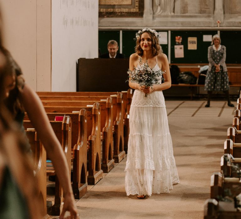 Bride walking down the aisle at intimate church ceremony wearing boho style Spell And The Gypsy dress