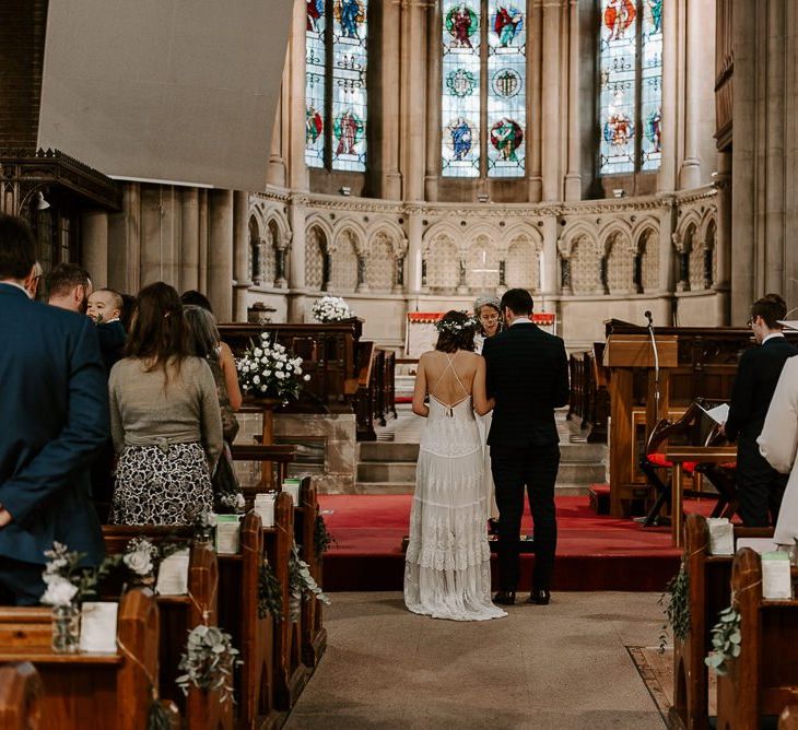 Bride and groom tie the knot at intimate church ceremony with bride wearing Spell And The Gypsy boho dress