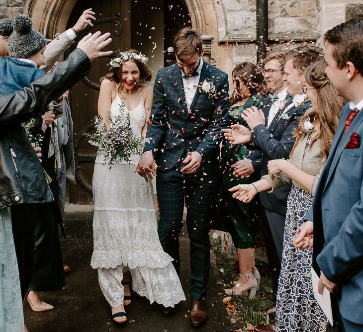 Church confetti shot with bride wearing Spell And The Gypsy boho dress teamed with a white floral crown and bouquet