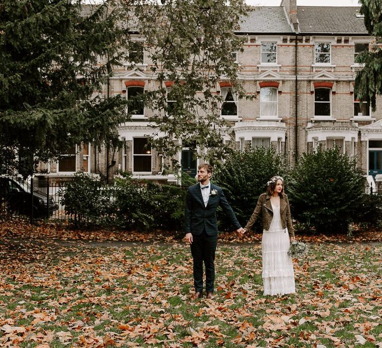 Bride wearing boho style Spell And The Gypsy dress with suede jacket and floral crown