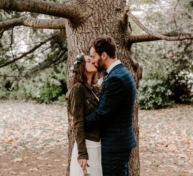 Bride and groom steal a moment with groom wearing checked suit and bride in a laced boho dress