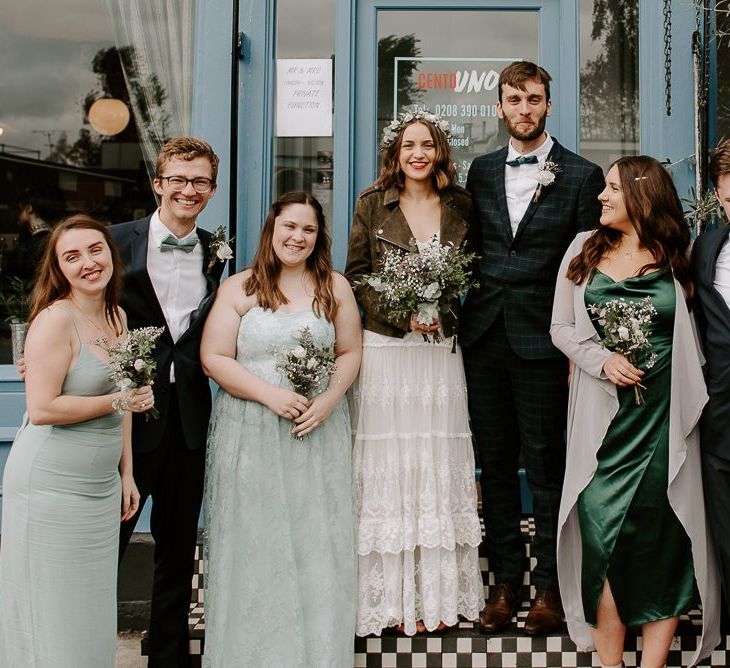 Intimate autumn wedding reception with boho bridal dress and green bridesmaid dresses