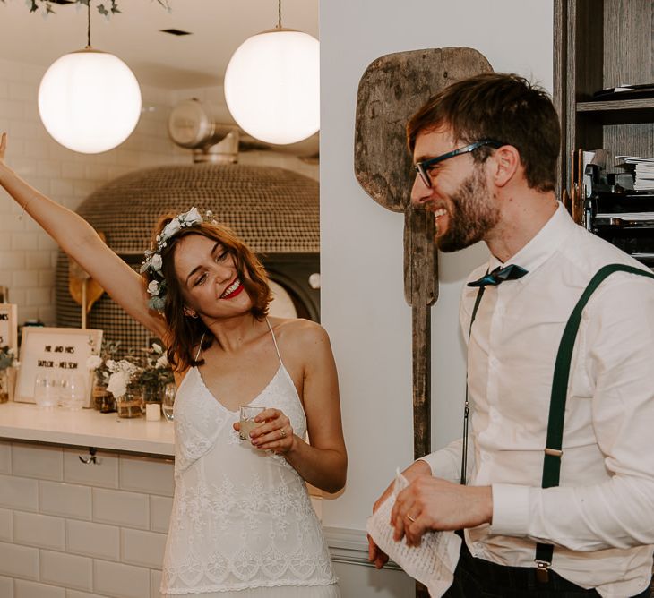 Bride and grooms speeches at intimate reception wearing laced boho dress and floral hair crown