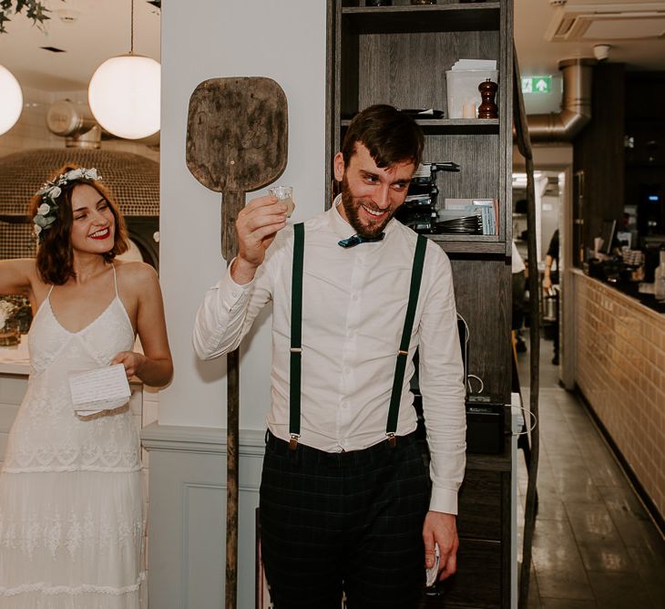 Bride and grooms speeches at intimate reception wearing laced boho dress and floral hair crown