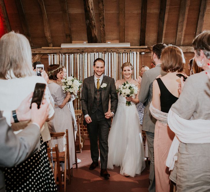 Wedding Ceremony | Bride in Essense of Australia Gown | Groom in  Grey Suit | Gold, Grey &amp; Green Rustic Wedding at The Gilbert White’s 16th Century Hampshire Barn | Joasis Photography