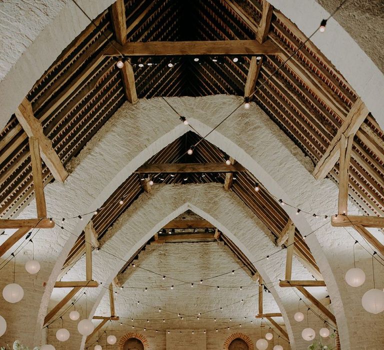 Wedding breakfast decor at Tithe Barn Petersfield with tall floral centrepieces