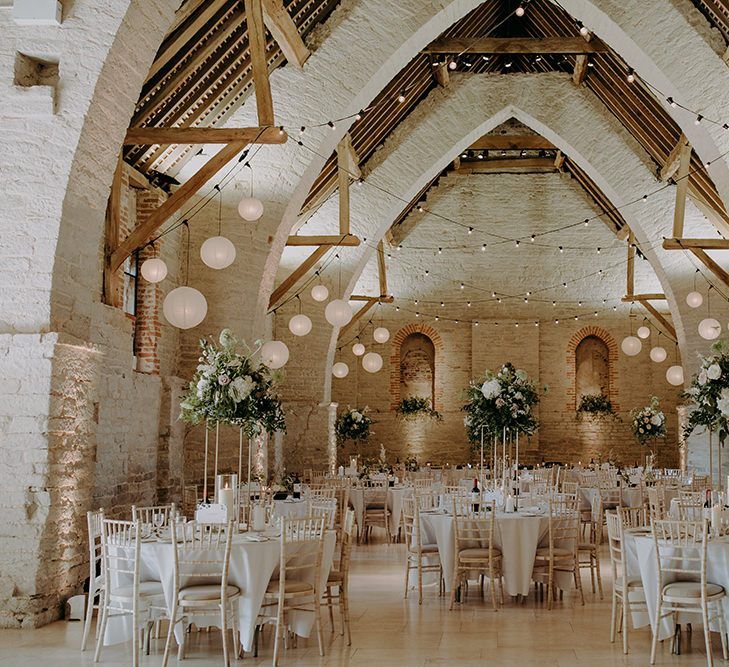 Wedding breakfast decor at Tithe Barn Petersfield with tall floral centrepieces