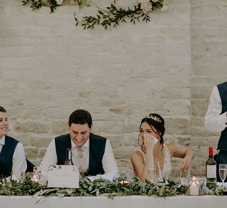 Bride and groom wipe tears at emotional wedding speeches