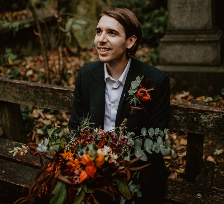 Groom in Black Suit Holding the Brides Oversized Wedding Bouquet