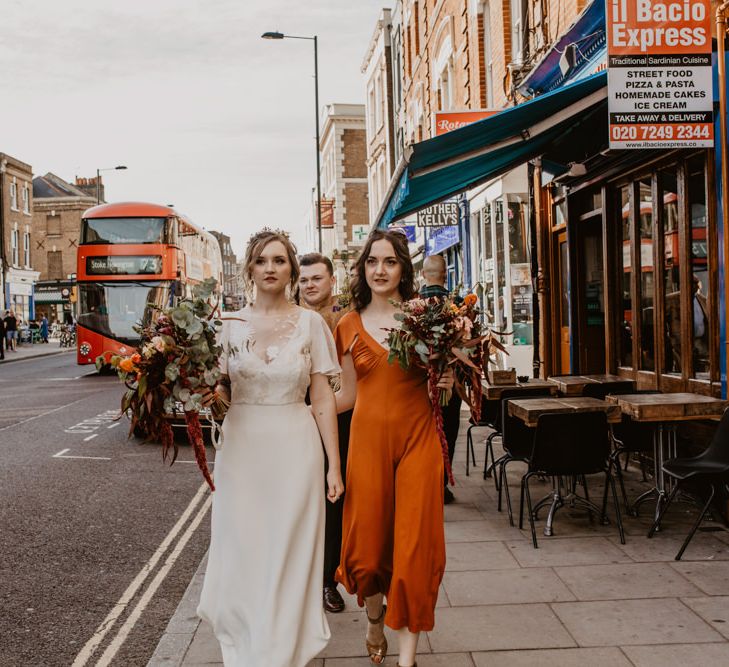 Bride and Bridesmaid Walking down the Urban Streets