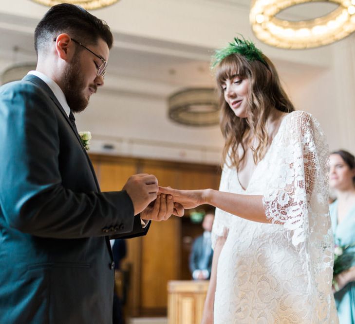 Bride in Grace Loves Lace Verdelle Dress with V-Neck, Low Square Back, Mid-Thigh Front Split and Lace Cape | Foliage Hair Crown | Groom in Blue Reiss Suit with Brown Grenson Shoes | Town Hall Hotel Bethnal Green | Neon Sign and Marine Green Rewritten Bridesmaids Dresses with Lace Cape Grace Loves Lace Gown | Alain Mbouche Photography