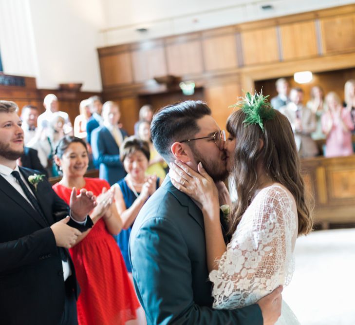 Bride in Grace Loves Lace Verdelle Dress with V-Neck, Low Square Back, Mid-Thigh Front Split and Lace Cape | Foliage Hair Crown | Groom in Blue Reiss Suit with Brown Grenson Shoes | Town Hall Hotel Bethnal Green | Neon Sign and Marine Green Rewritten Bridesmaids Dresses with Lace Cape Grace Loves Lace Gown | Alain Mbouche Photography