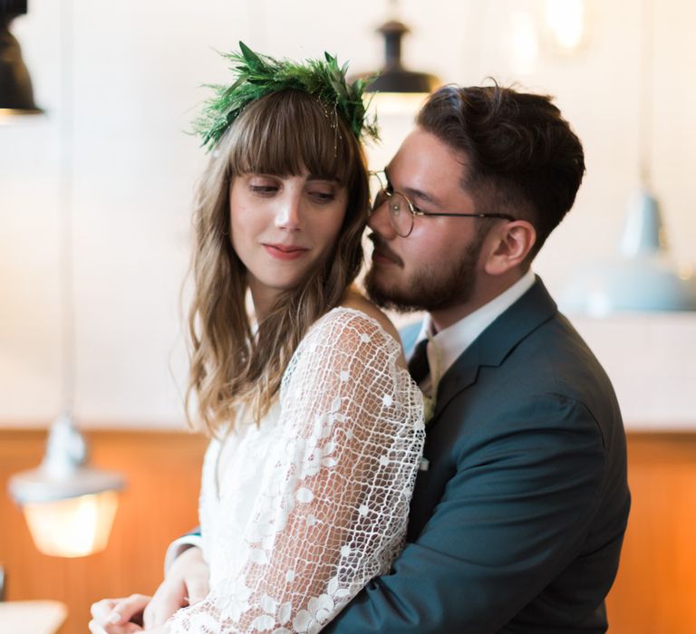 Bride in Grace Loves Lace Verdelle Dress with V-Neck, Low Square Back, Mid-Thigh Front Split and Lace Cape | Foliage Hair Crown | Groom in Blue Reiss Suit with Brown Grenson Shoes | Neon Sign and Marine Green Rewritten Bridesmaids Dresses with Lace Cape Grace Loves Lace Gown | Alain Mbouche Photography