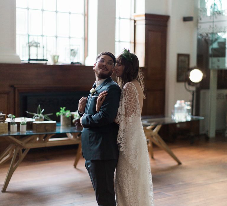 Bride in Grace Loves Lace Verdelle Dress with V-Neck, Low Square Back, Mid-Thigh Front Split and Lace Cape | Foliage Hair Crown | Groom in Blue Reiss Suit with Brown Grenson Shoes | Neon Sign and Marine Green Rewritten Bridesmaids Dresses with Lace Cape Grace Loves Lace Gown | Alain Mbouche Photography