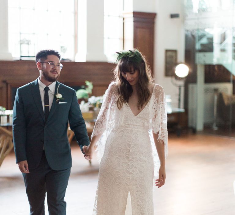 Bride in Grace Loves Lace Verdelle Dress with V-Neck, Low Square Back, Mid-Thigh Front Split and Lace Cape | Foliage Hair Crown | Gold Flat Gianvito Rossi Sandals | Groom in Blue Reiss Suit with Brown Grenson Shoes | Neon Sign and Marine Green Rewritten Bridesmaids Dresses with Lace Cape Grace Loves Lace Gown | Alain Mbouche Photography