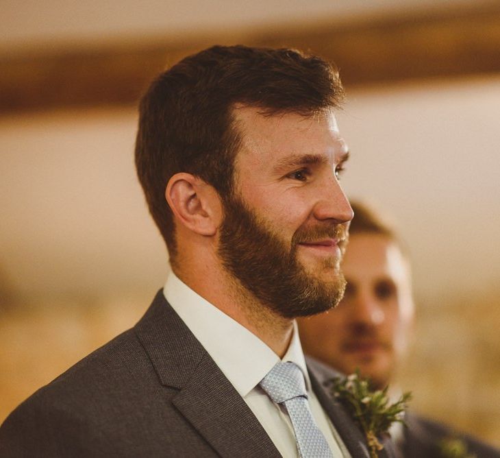 Grooms smiles as he sees bride