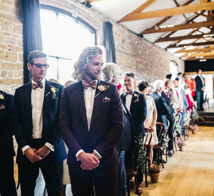 Groom in Burgundy Paul Smith Suit Standing at The Altar of a Barn Wedding Ceremony