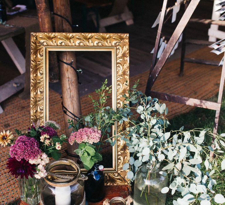 Wedding Decor with Gold Guilt Frame and Flower Stems in Jars