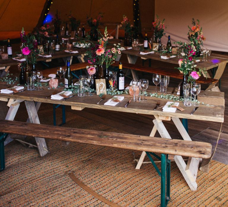 Wooden Tables with Bottles Filled with Colourful Flower Stems