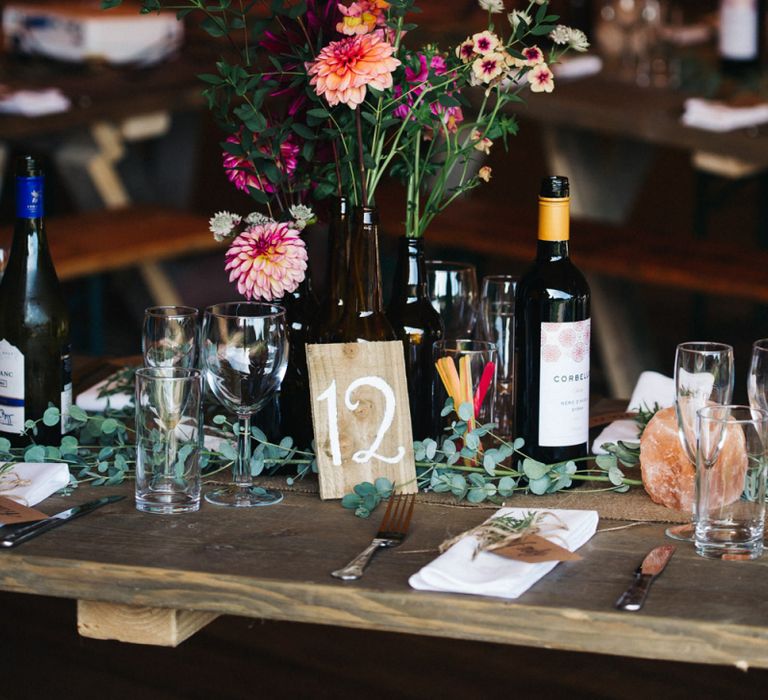 Table Centrepiece with Bottles Full of Colourful Flower Stems