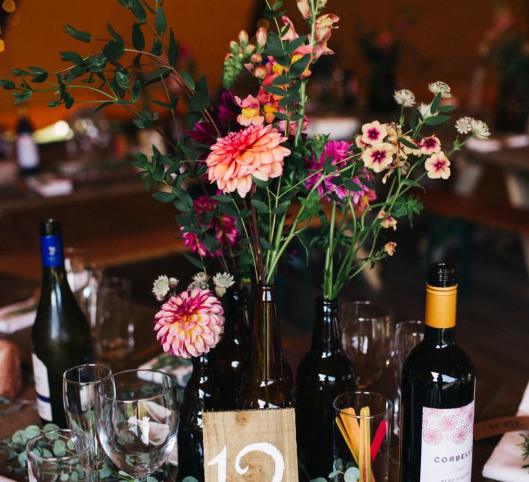 Wedding Decor of Colourful Flower Stems in Bottles