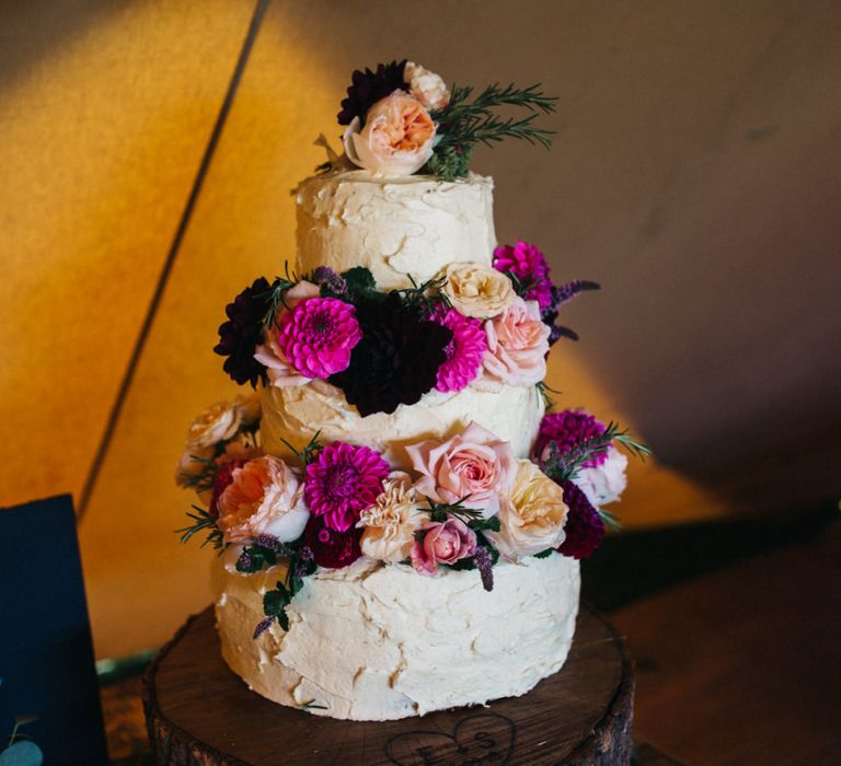 Buttercream Wedding Cake with Colourful Flowers Decor on a Tree Slice Cake Stand