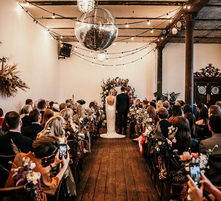 Clapton Country Club wedding ceremony with festoon lighting and a disco ball