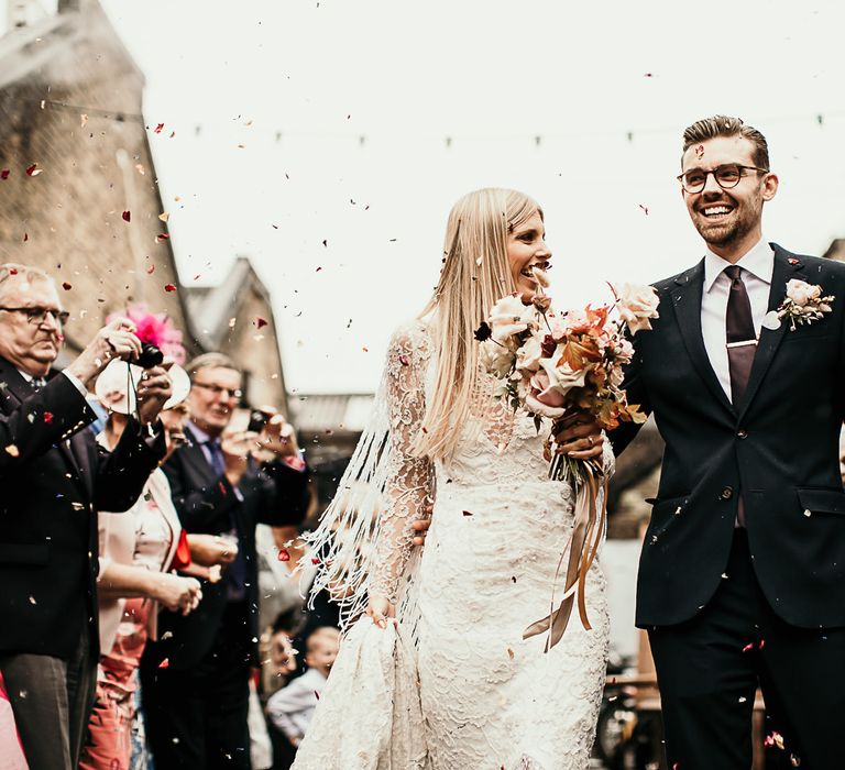 Bride and groom tie the knot at Clapton Country Club wedding ceremony with botanical styling and festoon lighting