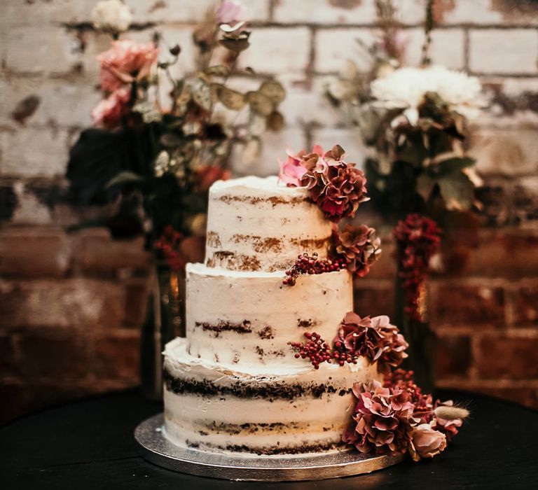 Semi naked cake with pink floral decoration for city industrial styled celebration